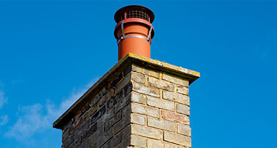 a chimney with a mesh cowl and bird guard installed onto it