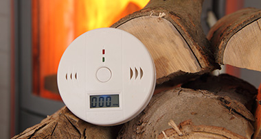 a carbon monoxide detector next to firewood 