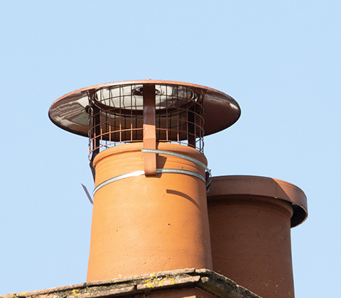 a close up to a chimney with a cowl and cover installed