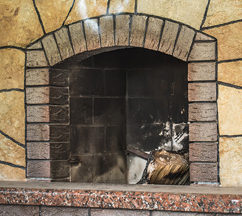 a dirty beige-brick fireplace